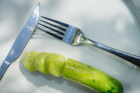 Cucumber on white plate on wooden background for eatの写真素材