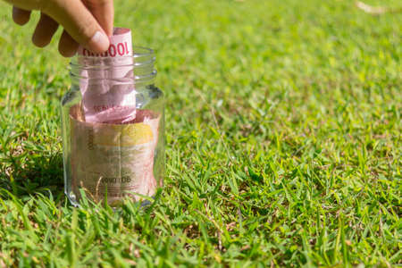 Hundred Thousand Rupiah Paper Money in jar on Green Nature Backgroundの写真素材
