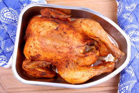 Baked whole marinated chicken in aluminum foil tray