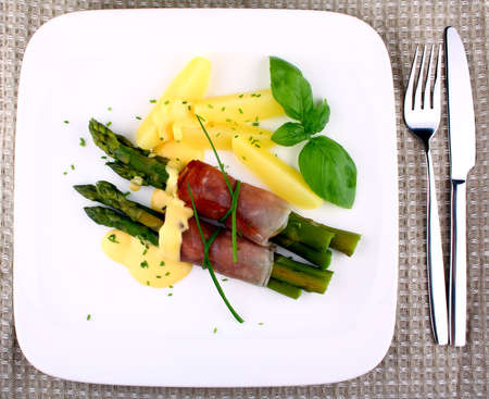 Green asparagus with ham, potato and sauce, top viewの写真素材