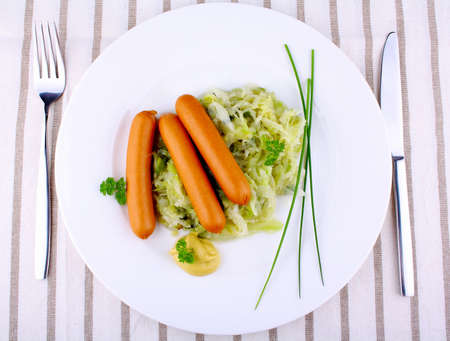 Mini wieners on fried cabbage with mustard, top viewの写真素材
