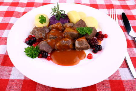 Red deer goulash with potato, Burgundy sauce and wild berries, close upの写真素材