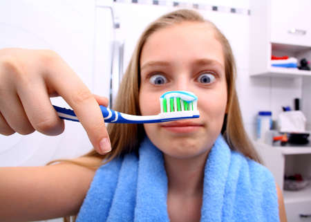 Blonde girl is surprised when brushing your teeth, soft focusの写真素材