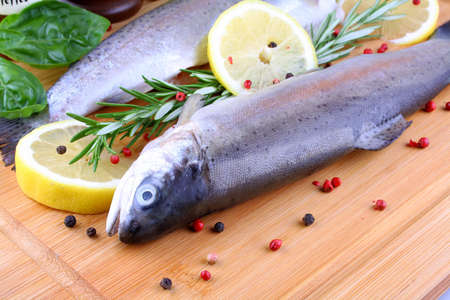 Two fresh full trout with species on bamboo board, horizontalの写真素材