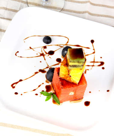 Grapefruit, kiwi and orange dessert with chocolate sauce, top viewの写真素材