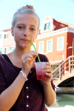 Cute girl with red slush drink, close upの写真素材
