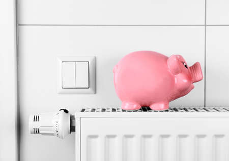 Pink piggy bank saving not electricity and heating costs, close up