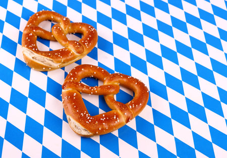 Two pretzel in heart shape on white blue background, top view