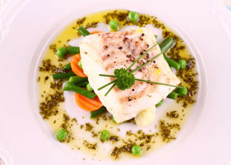 Cod Fillet with green beans, peas, parsley, olive oil, top view