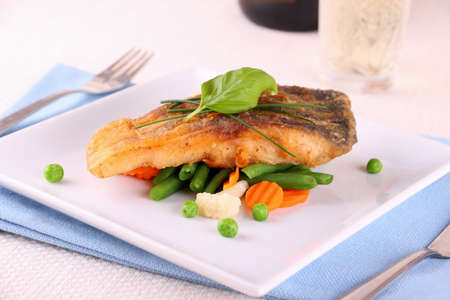 Fried carp fish fillet with vegetables, close up
