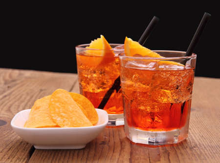 Spritz aperitif - two orange cocktail with ice cubes, potato chips