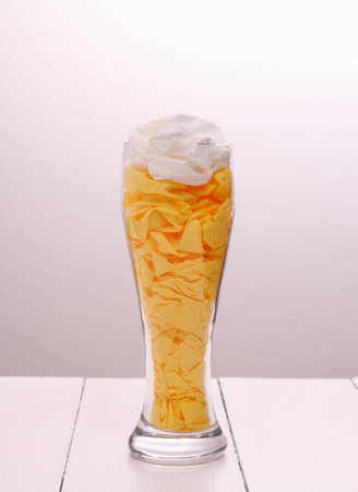 Beer glass filled with paper napkins as decorative, verticalの写真素材