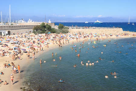 ANTIBES, FRANCE - AUG 27, 2014: People relaxing on the public beach as backgroundのeditorial素材