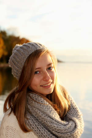 Pretty girl in autumn by the lake, close upの写真素材