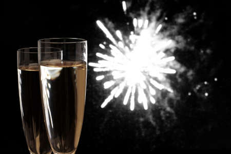 Two Champagne glasses at night fireworks backgroundの写真素材
