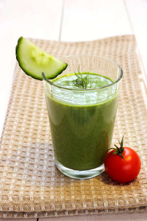 Green smoothie spinach, cucumber and small red tomato, close upの写真素材