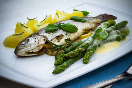 Grilled trout with green asparagus and rosemary potatoes, sauceの写真素材