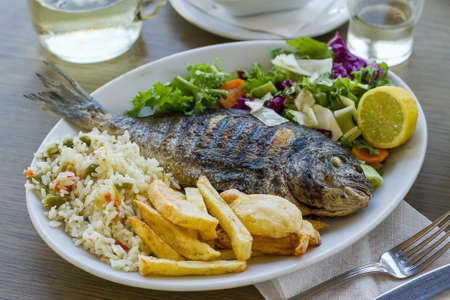 Bream with potato, rice and salad, Greek foodの写真素材