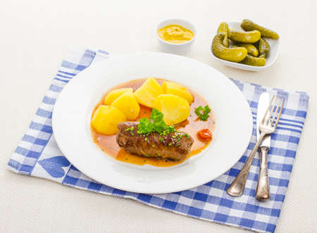 Roulades beef on plate with sauce, mustard and gherkins, top viewの写真素材