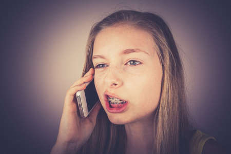 Portrait teenage girl telephoned indignantly, grain effect, vintage, old fashionの写真素材