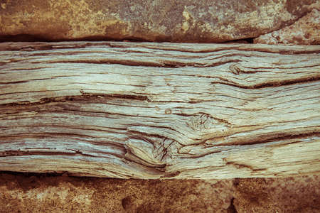 Old wooden beams between stone wall as backgroundの写真素材