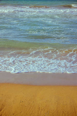 Soft foam wave of sea on sandy beach verticak as background