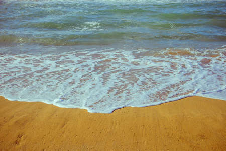 Soft foam wave of sea on sandy beach as background
