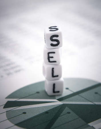 Tower word sell from letters cube on diagram stock report, soft focus