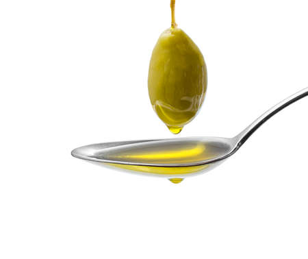 Green olive on stalk with full oil spoon, isolatedの写真素材
