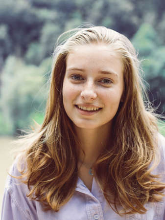 Cute teenage girl portrait with blond hair smiles