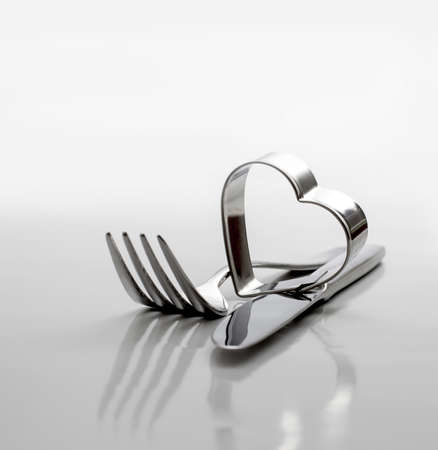Cutlery, fork with knife and heart on grey backgroundの写真素材