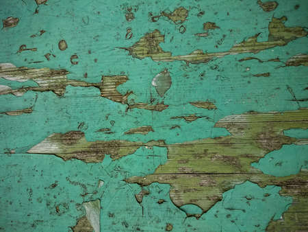 Grunge wood background with old green peeling paint, top view