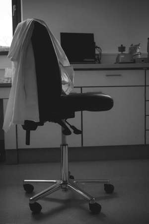 Empty laboratory chair with lab coat. End of work conceptの写真素材
