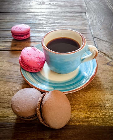 Cup of coffee and french macarons on an old woodenの写真素材