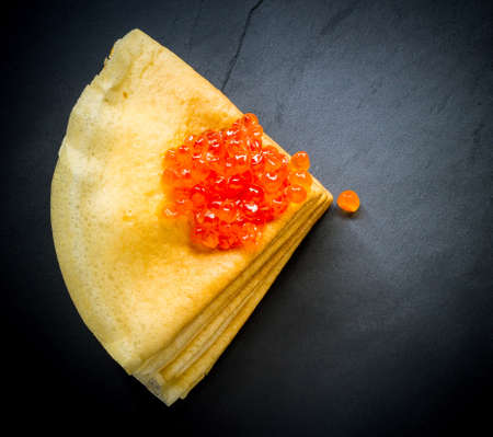 Red caviar on pancakes stack on black backgroundの写真素材