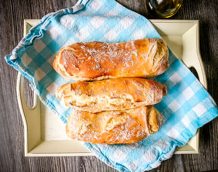 Three white bread baguett with olive oil, top view
