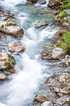 Forest mountain river running over rocks, as small brookの写真素材