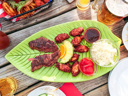 Beef steak with chicken wings and fruits, top viewの写真素材