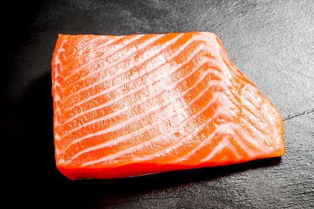 Beautiful salmon fillet on slate plate, top viewの写真素材