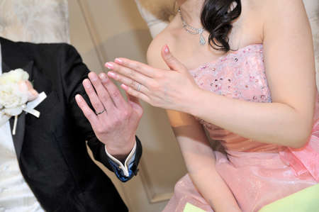 Wedding ring bride and groom unveiling hand up of wedding ringの写真素材