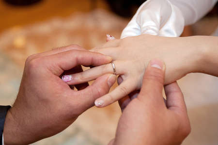 Ring exchange hand up from the groom to the brideの写真素材