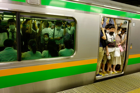 Commuting people waiting for the train to depart on the subway platform