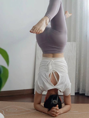 Young woman practicing yoga poses on the floor, equipment, etc.