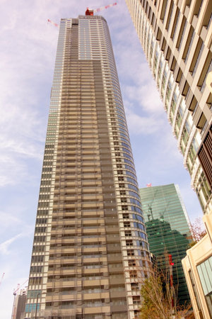 Tokyo, Japan â€“ January 5, 2025: A modern skyscraper stands tall against a blue sky in...