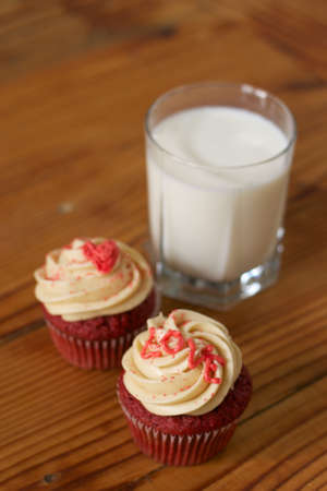 Two Red Velvet Cupcakes with a glass of milkの写真素材