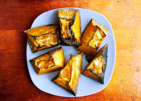 Slices of baked pumpkin on plate and wooden tableの写真素材