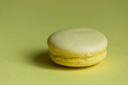One Yellow lemon macaroon on yellow background.の写真素材
