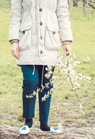 Young beautiful Turkish girl holding spring cherry flowers in her hands. Retro filter applied.の写真素材
