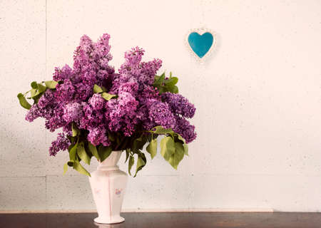 Lilac in a Vase and small heart-shaped mirror on the wall.の写真素材
