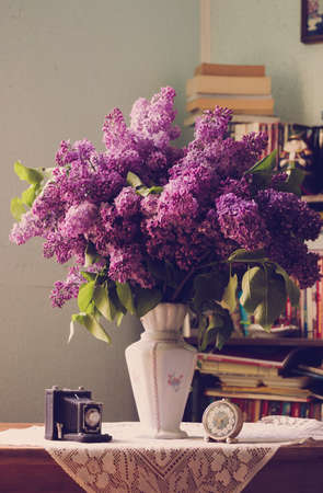 Lilac in a Vase and accessoris near the library indoors with natural light.の写真素材